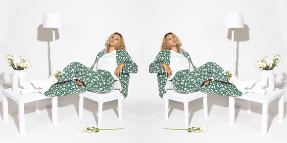 banner featuring woman wearing green flower suit sitting on chair
