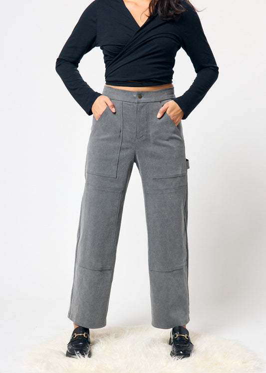 Person wearing gray pants and a black top on a white background