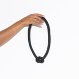 hand holding black knot necklace