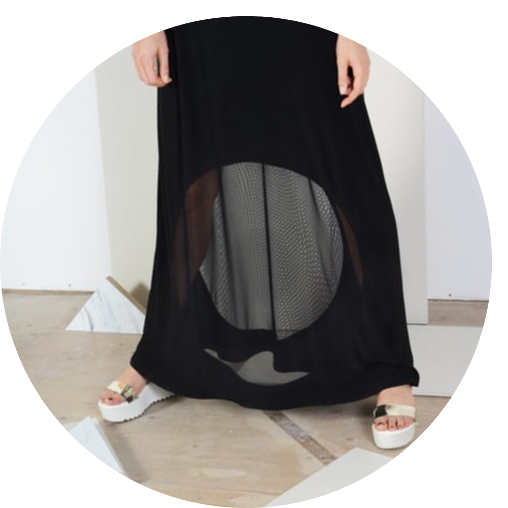 woman standing with a black dress on that has a mesh circle in it