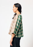 Woman wearing brown and green checkered shirt