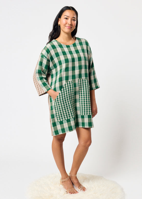 Woman wearing a green and white checkered dress on a white background