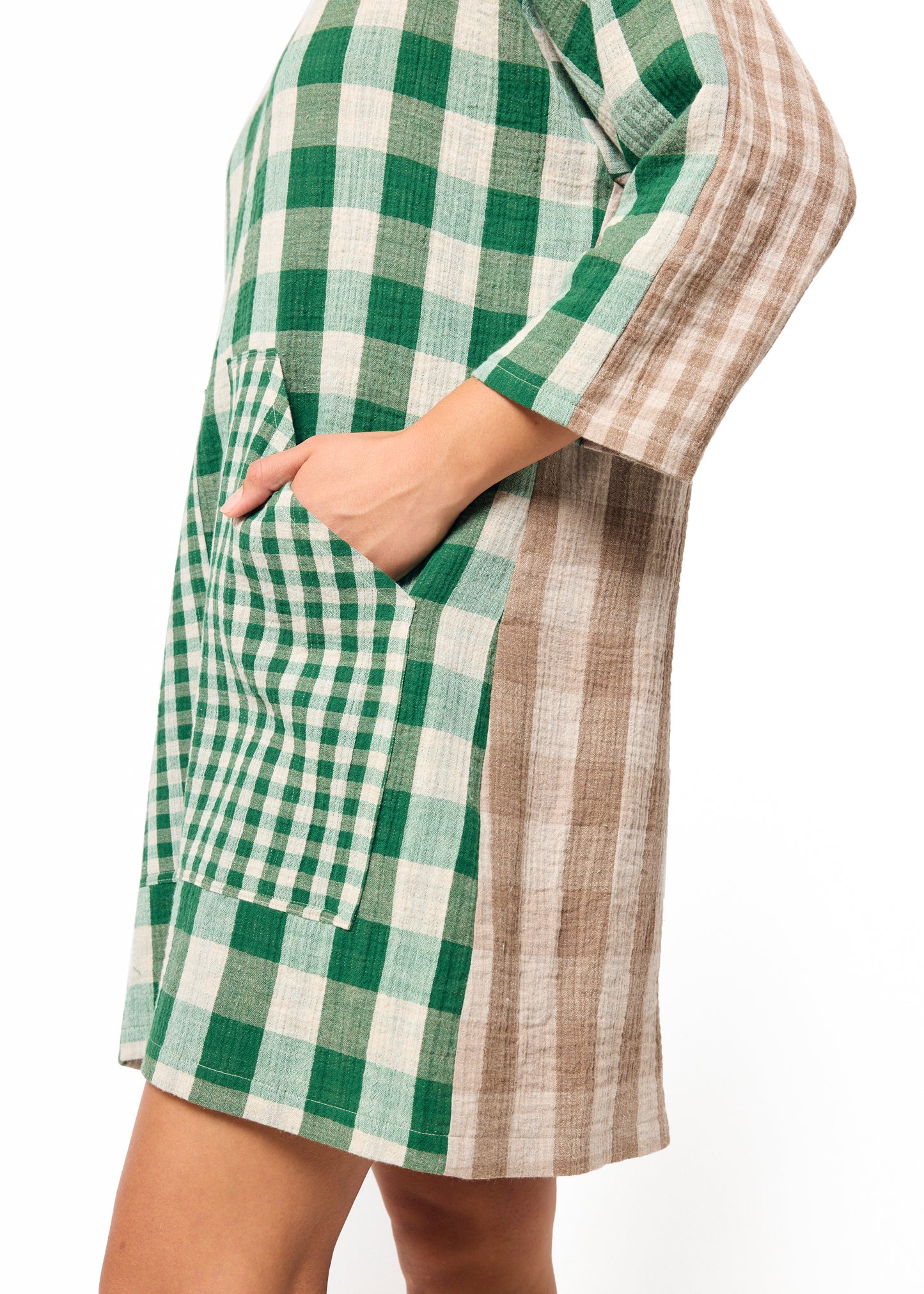 Green and white checkered dress worn by a person on a white background