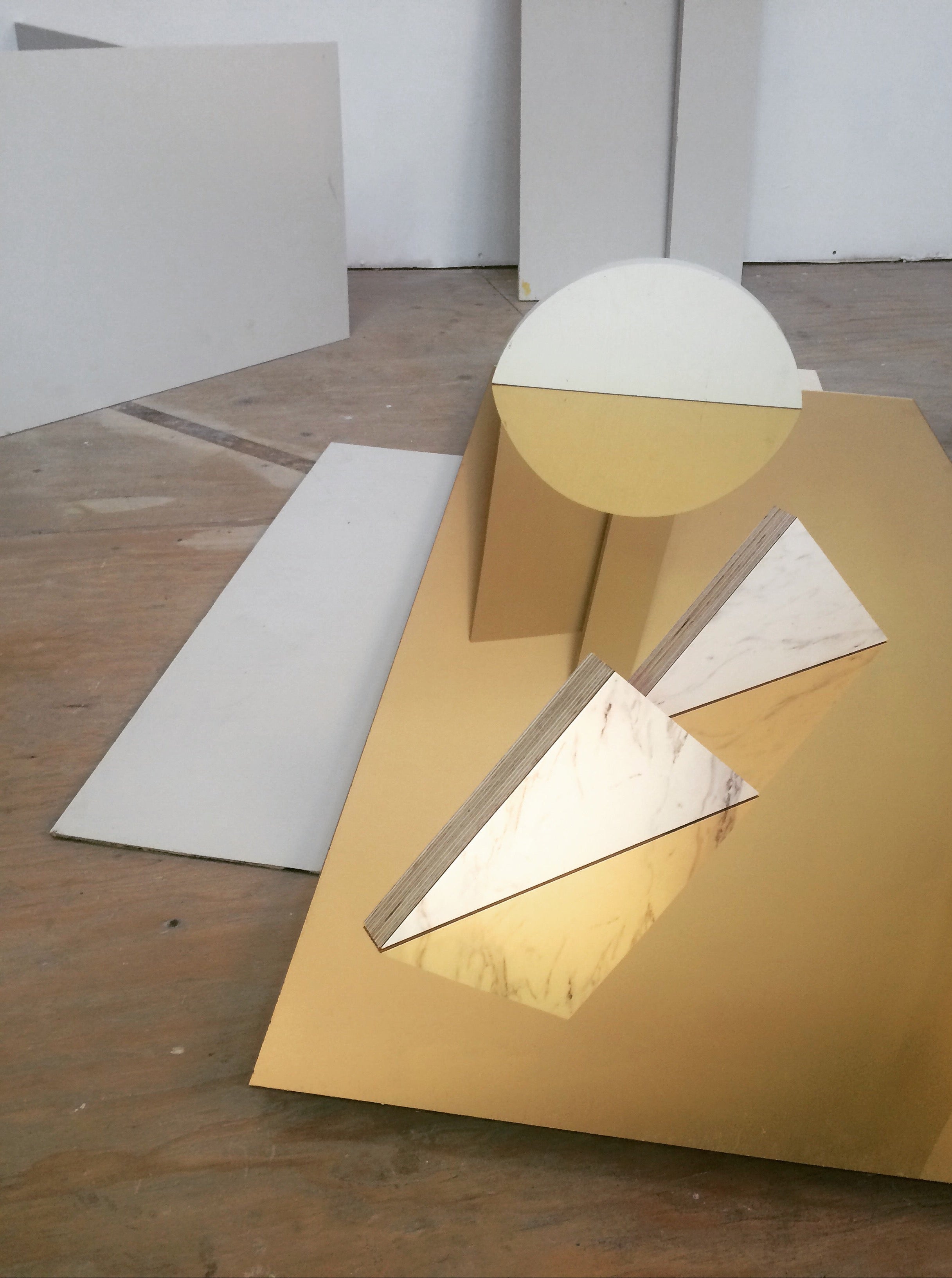 Abstract geometric sculpture on a wooden floor with white walls