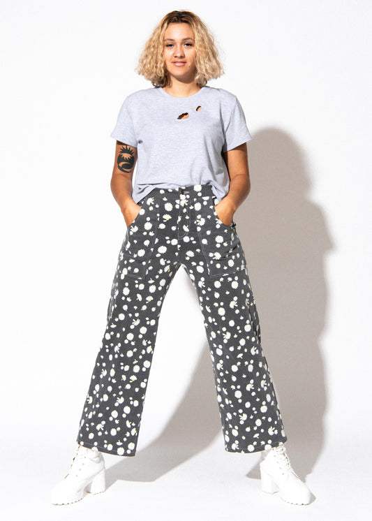 Person wearing a white t-shirt and patterned pants on a white background