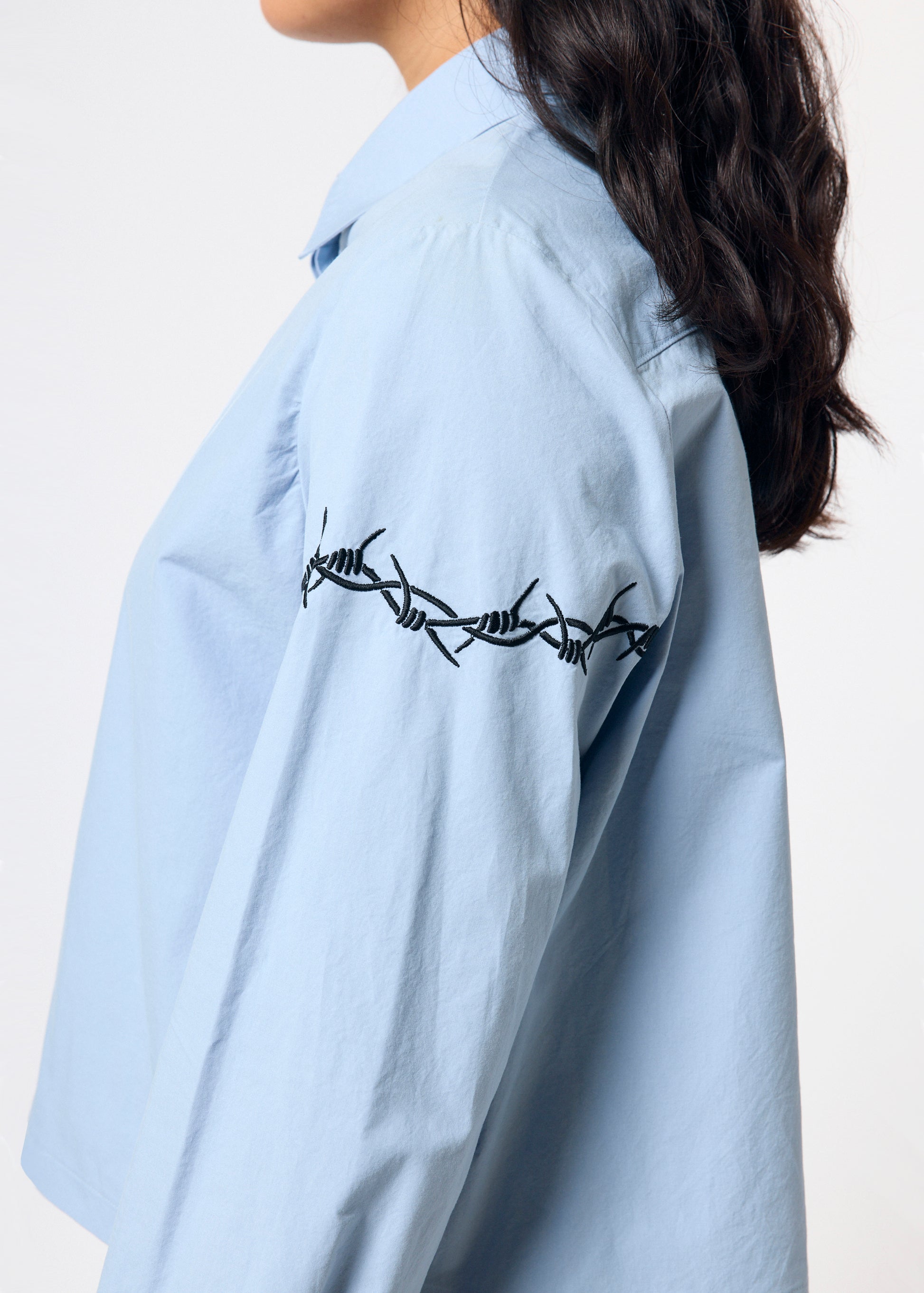 Light blue shirt with barbed wire design on a plain background