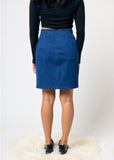 Person wearing a blue skirt and black top on a white background