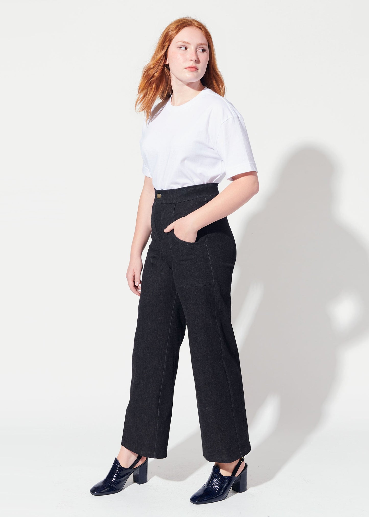 Woman wearing a white t-shirt and black pants on a white background