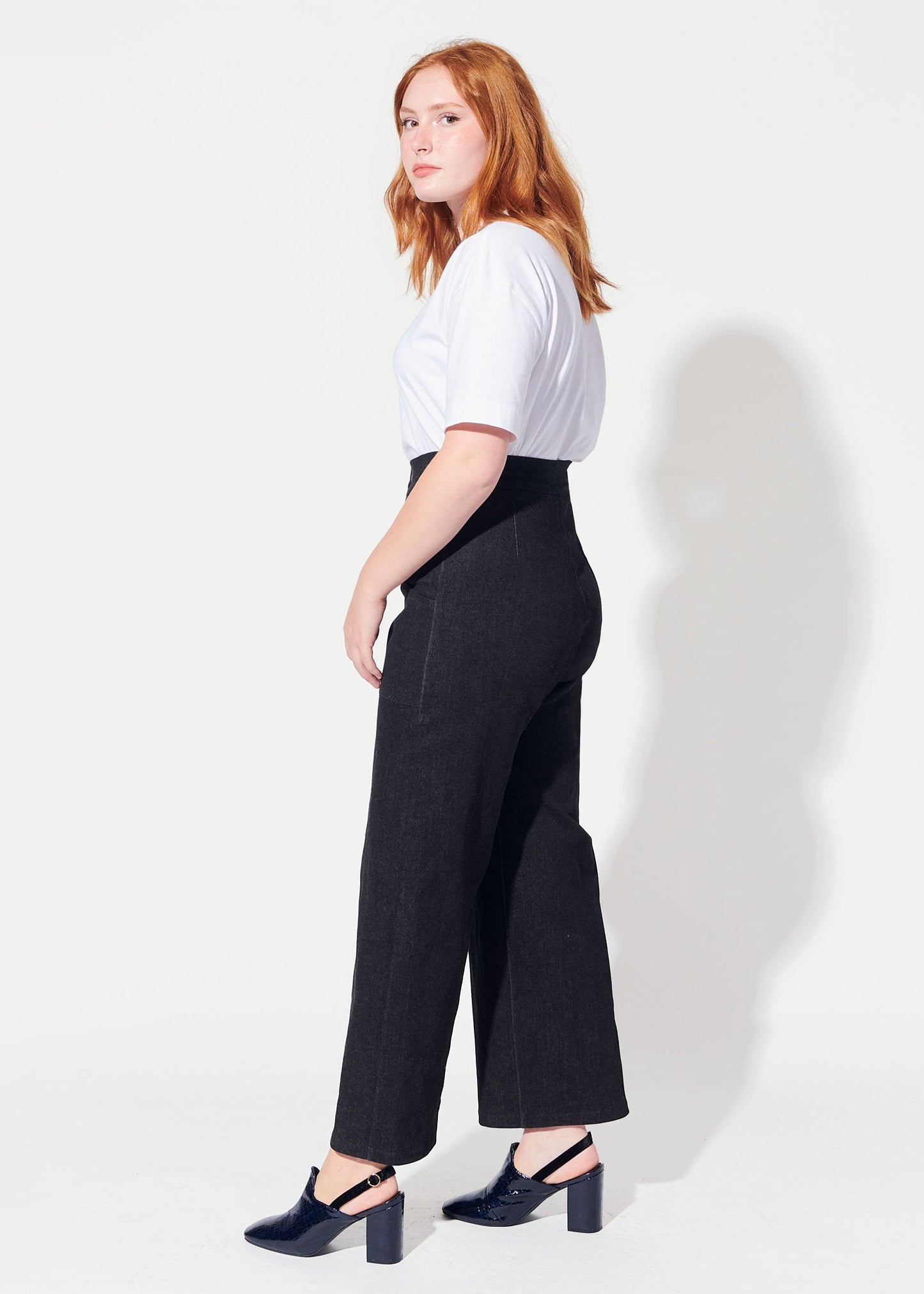 Woman wearing a white top and black wide-leg pants on a white background
