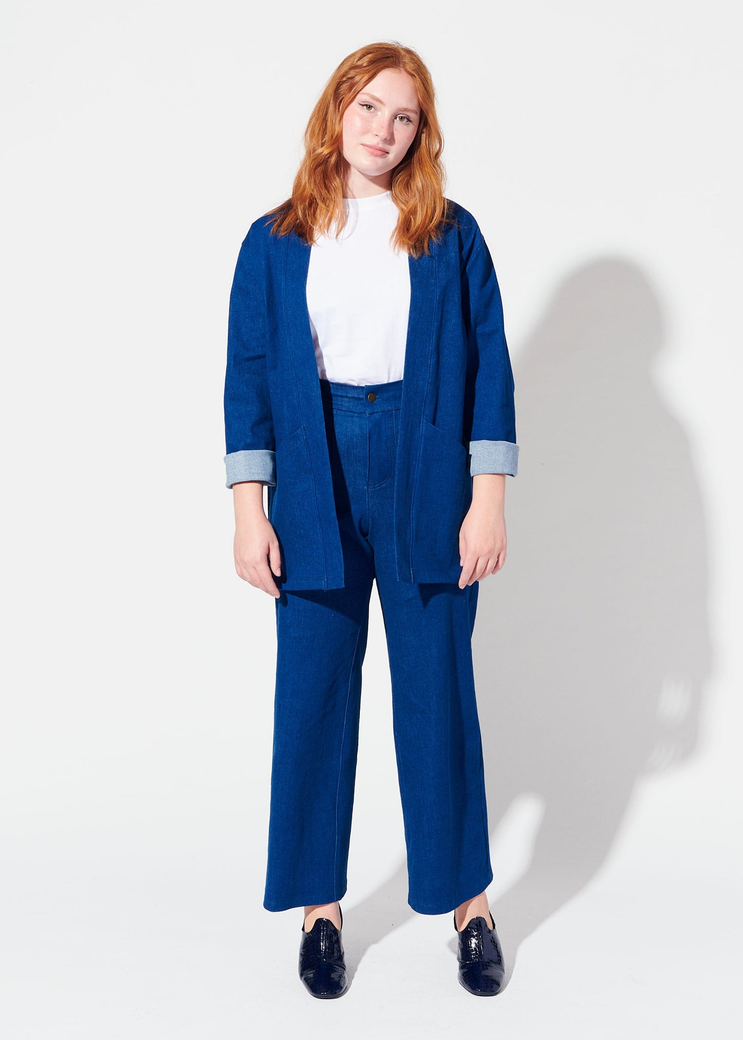 Woman wearing a blue suit with a white shirt on a white background