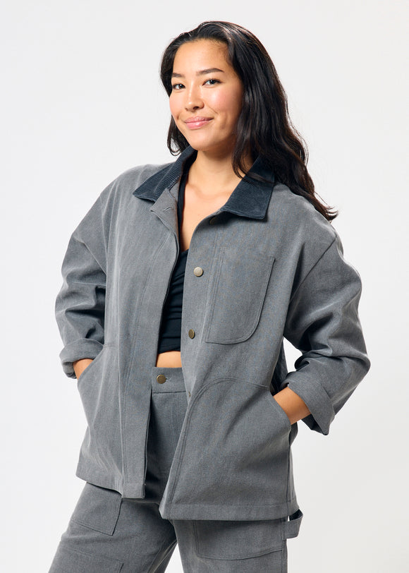 Woman wearing a gray jacket and pants on a white background