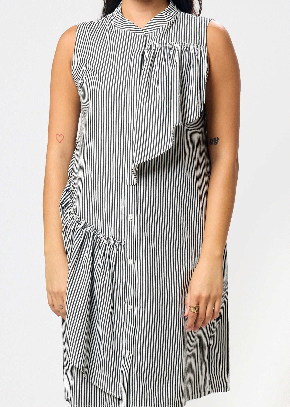 Woman wearing a black and white striped dress on a plain background