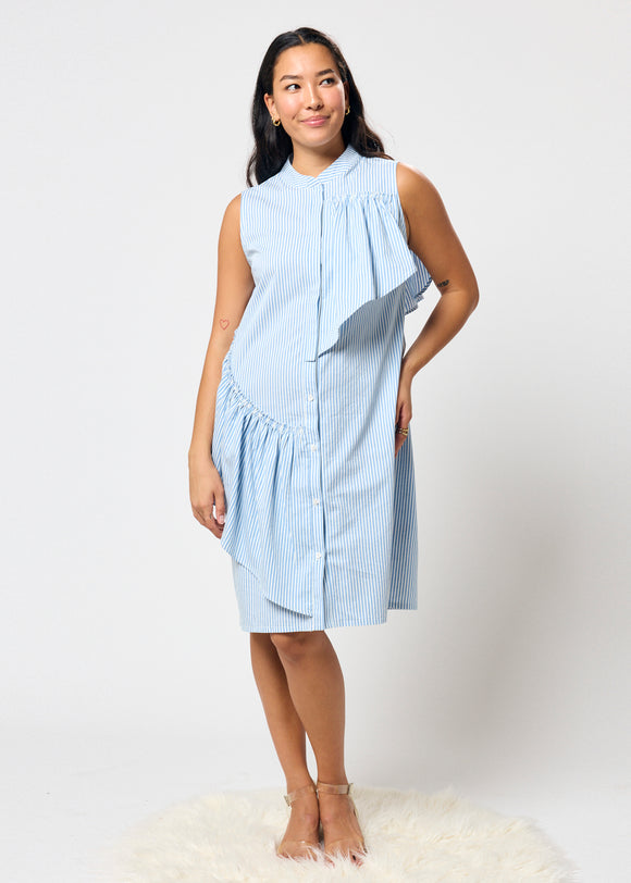 Woman wearing a blue striped dress with ruffleson a white background