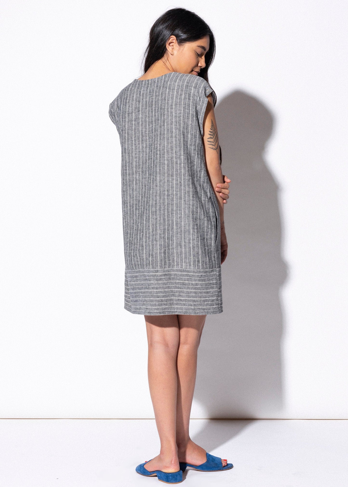 Woman wearing a sleeveless dress with a white background