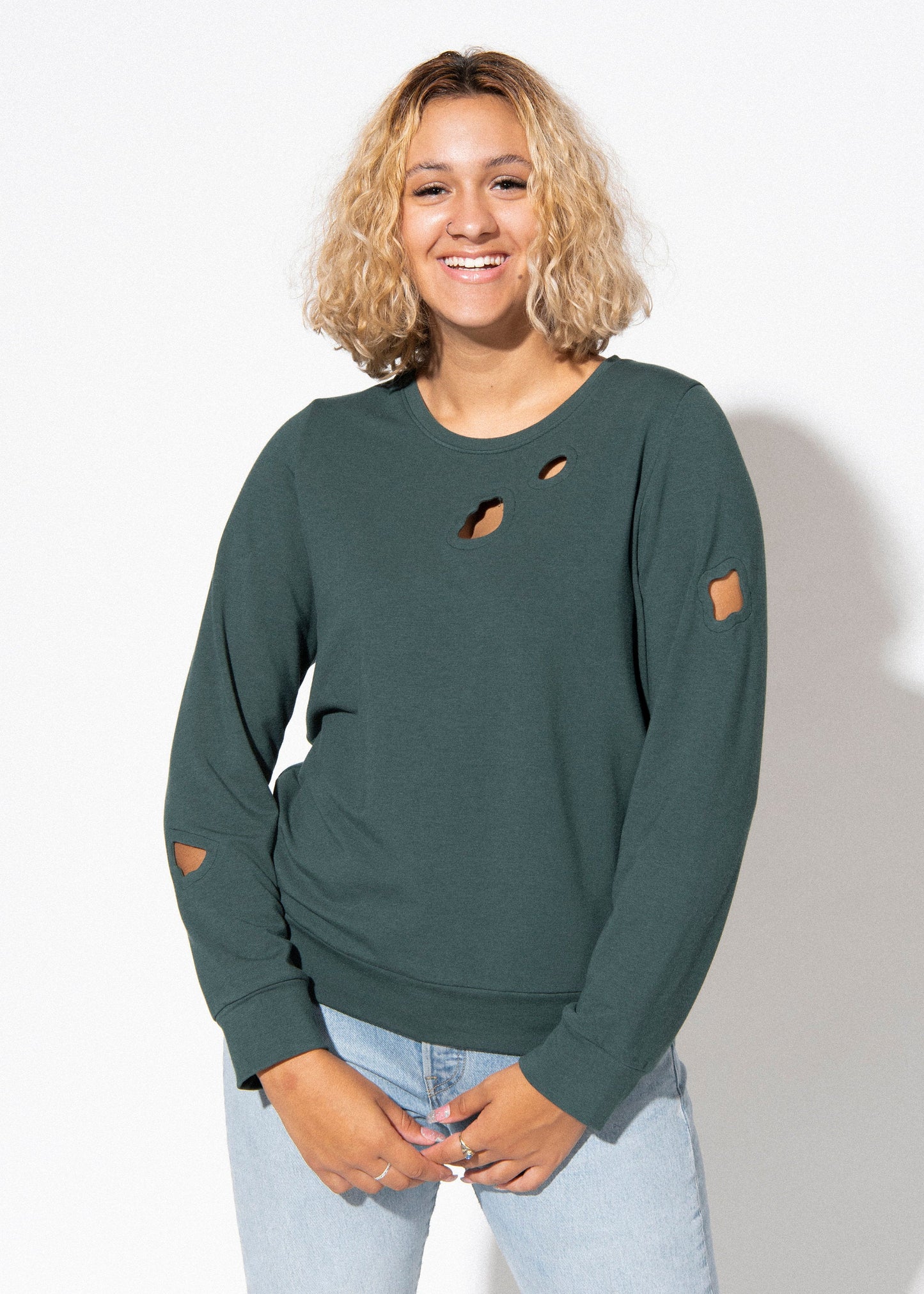 Person wearing a green distressed sweatshirt against a white background