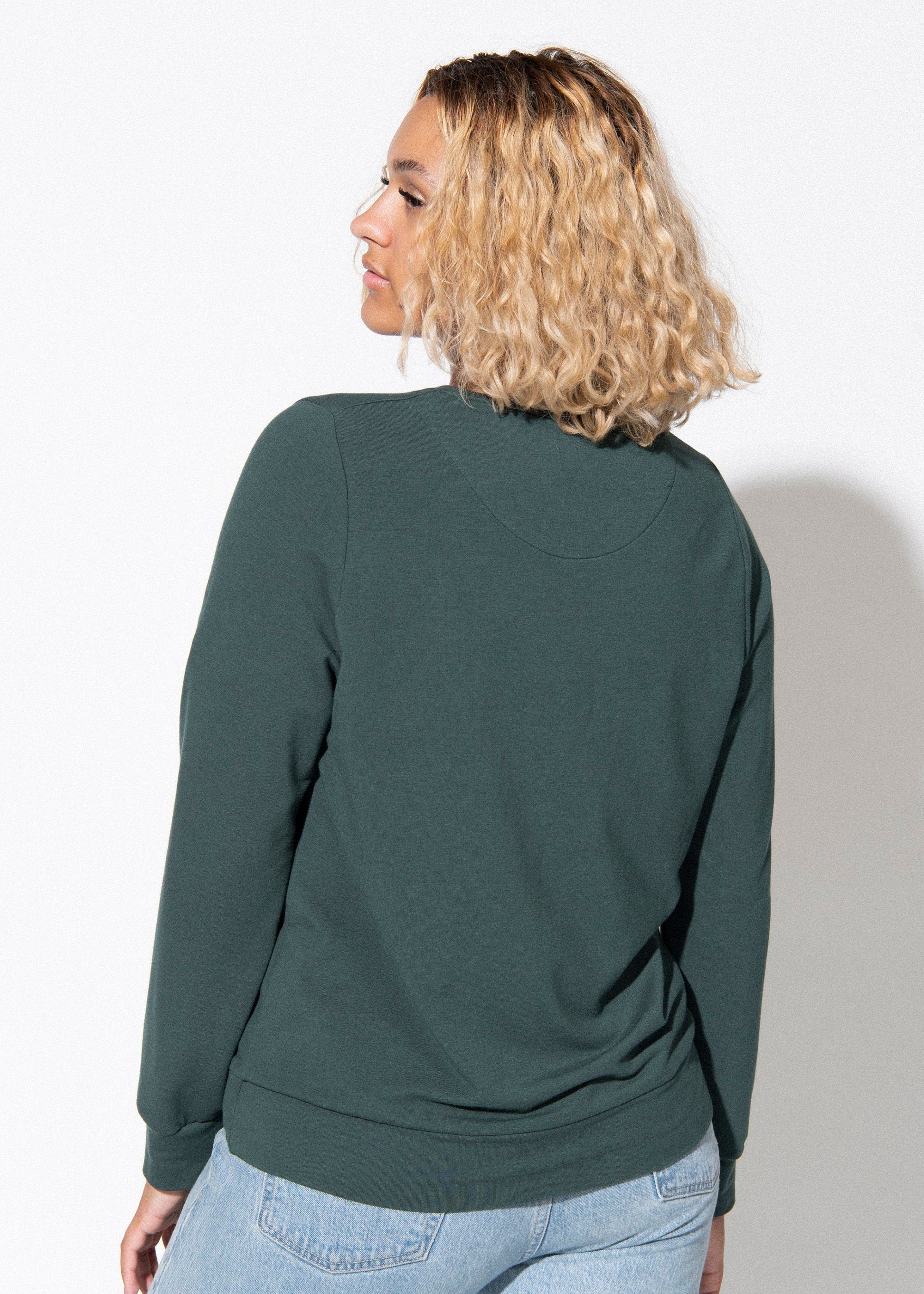 Person wearing a green sweatshirt against a white background