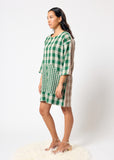 Woman wearing a green and white checkered dress on a white background