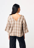 Woman wearing a plaid shirt with a plain background