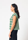 Woman wearing a green and white checkered top on a white background