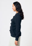 Woman wearing a black sweatshirt with black tassels against a white background