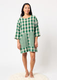 Woman wearing a green and white checkered dress on a white background