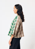 Woman wearing a green and beige checkered shirt on a white background