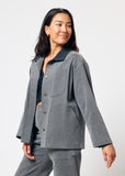 Woman wearing a gray jacket and pants on a white background