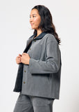 Woman wearing a gray jacket and pants on a white background