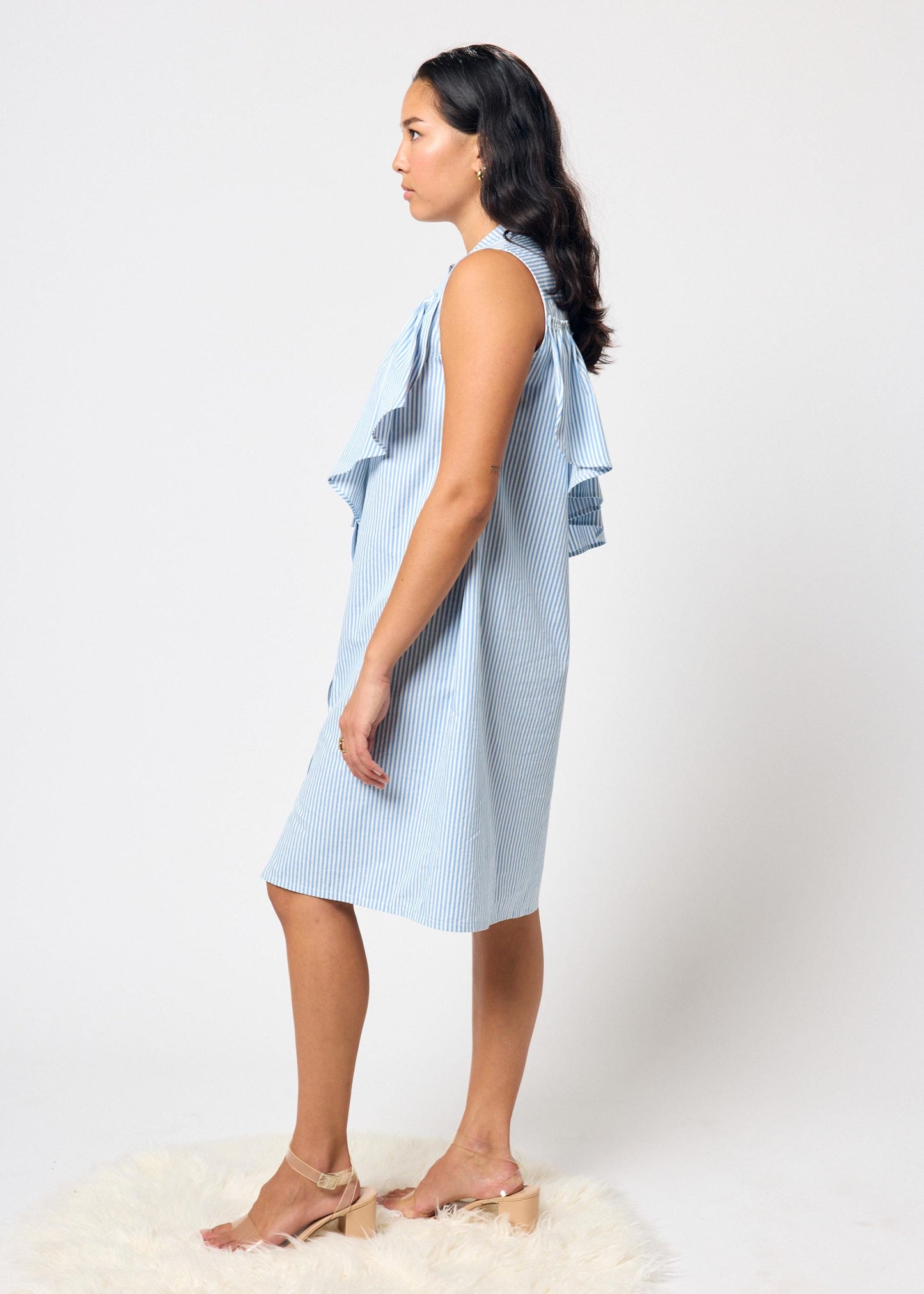 Woman wearing a blue and white striped dress on a white background