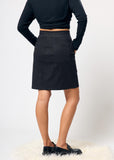 Person wearing a black skirt and black top on a white background