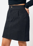 Dark denim skirt worn by a person on a white background