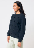 Woman wearing a black sweater with black tassels on a white background
