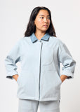 Person wearing a light blue jacket on a white background