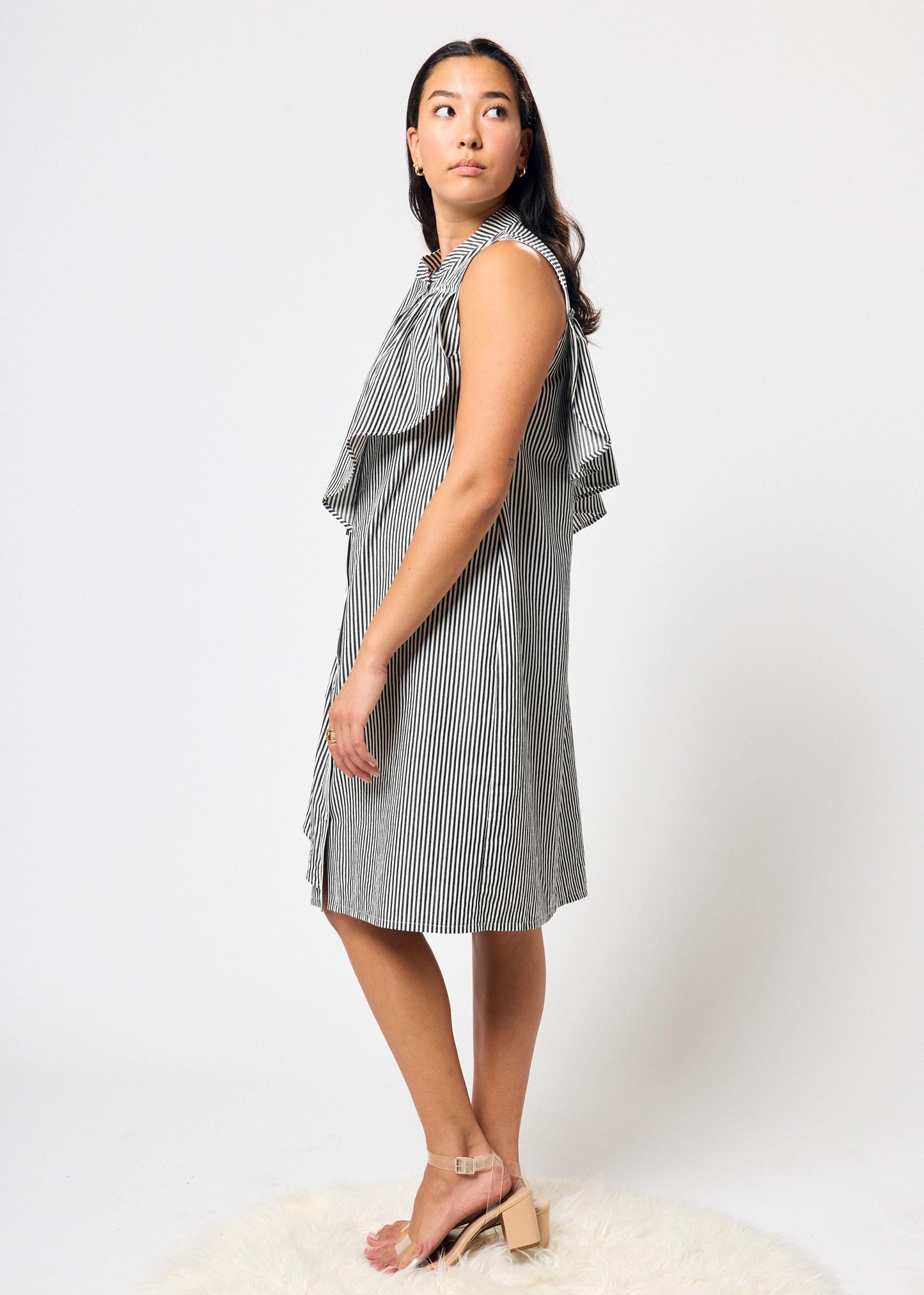 Woman wearing a black and white striped dress on a white background