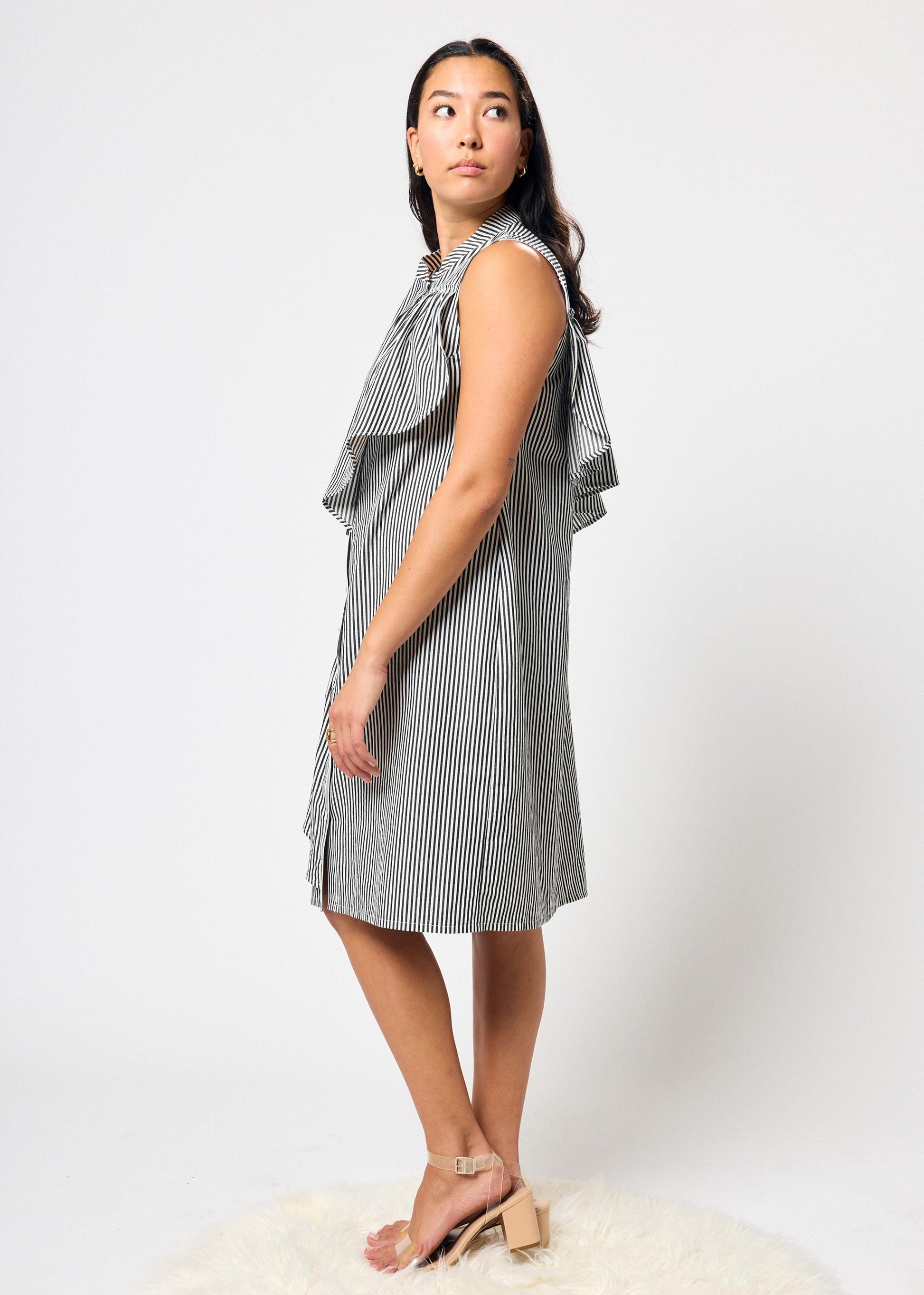 Woman wearing a black and white striped dress on a white background