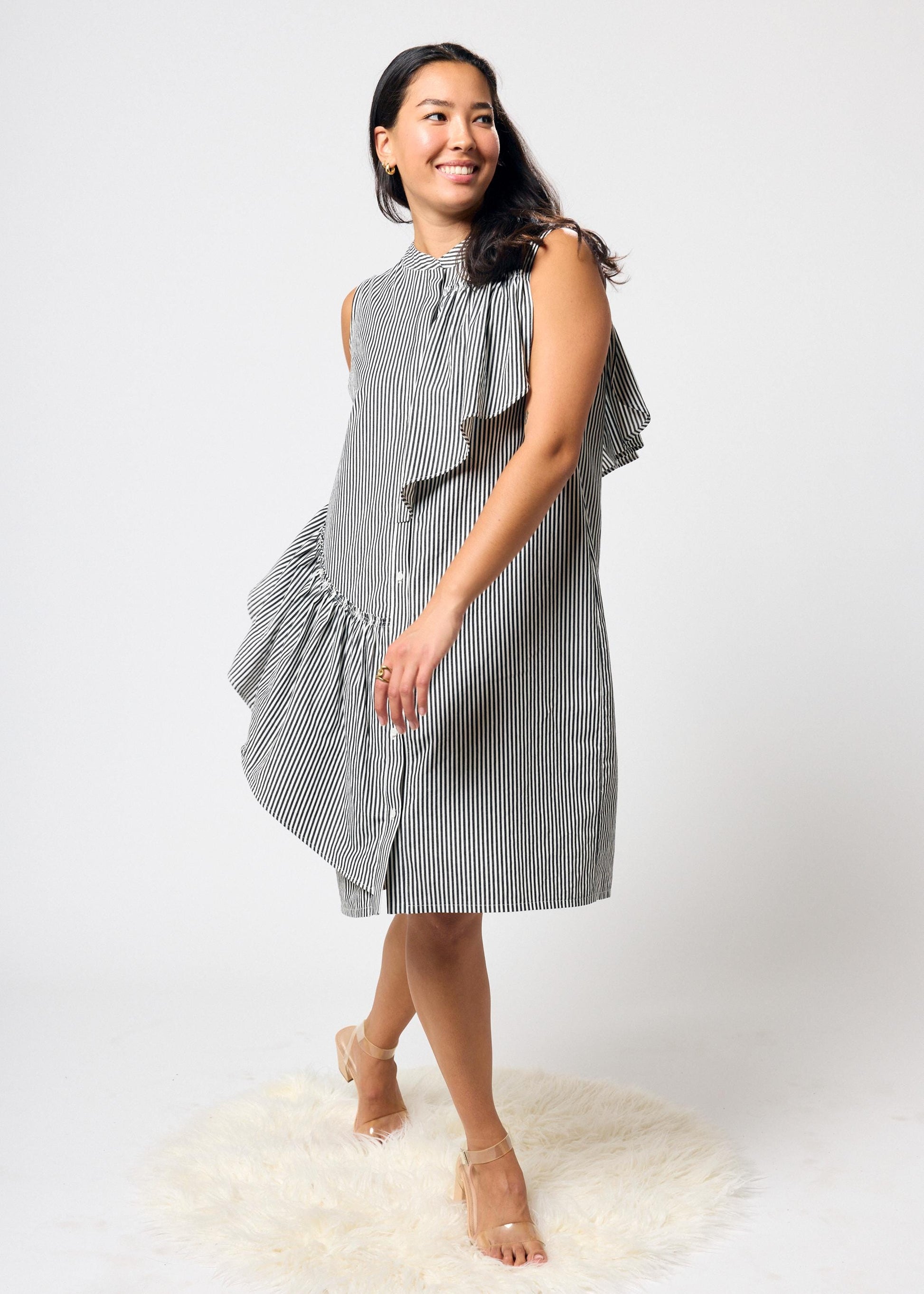 Woman wearing a black and white striped dress on a white background