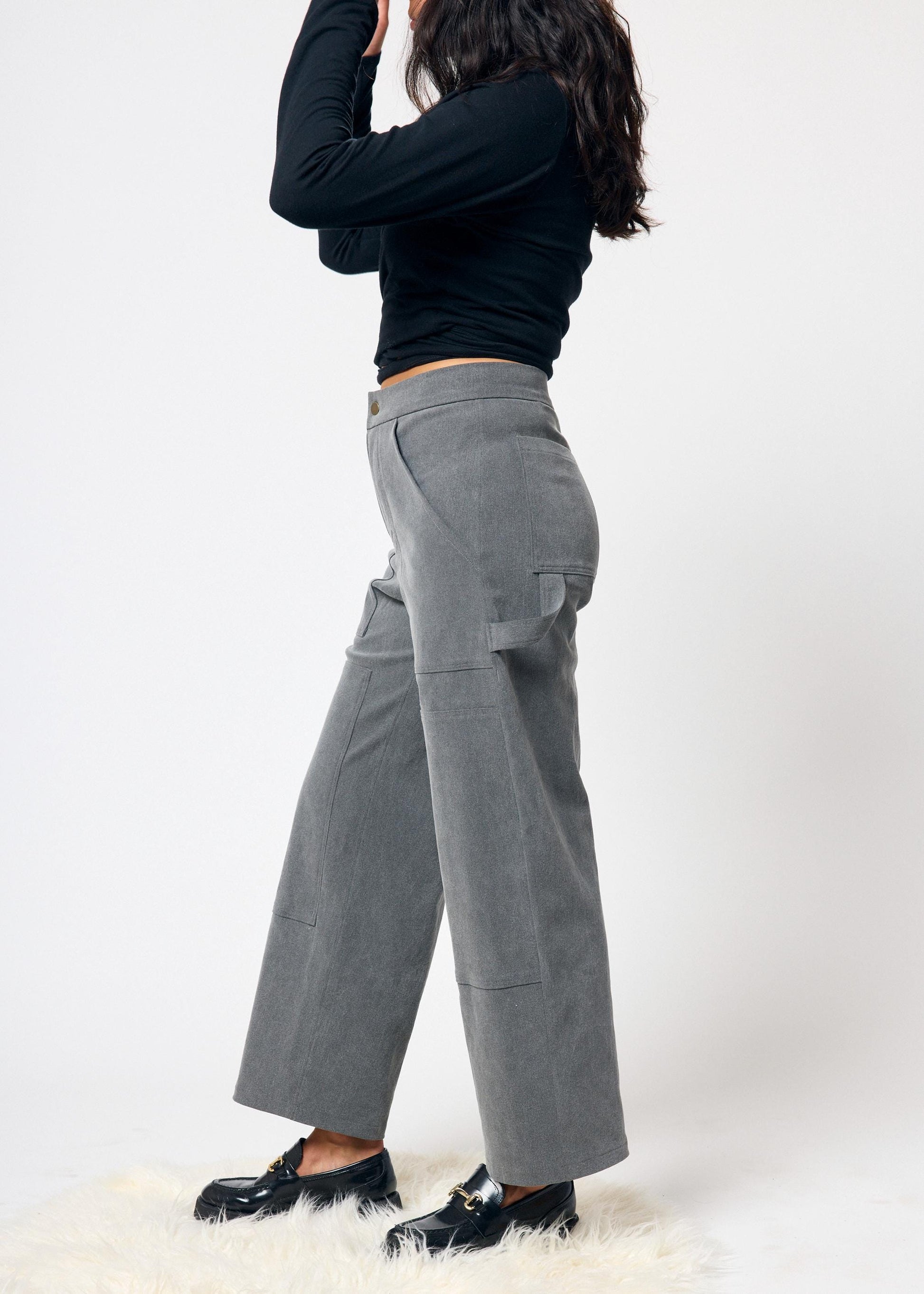 Person wearing gray pants and black shoes on a white background