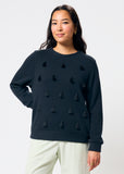 Woman wearing a black sweater with black tassels on a white background