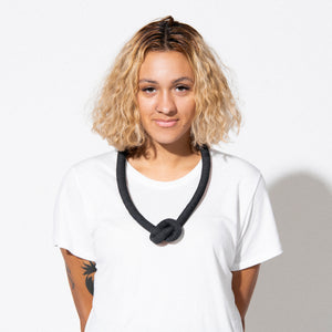 woman wearing black knot necklace
