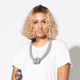 woman is wearing knot necklace gray 
