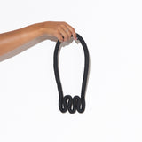 squiggle necklace black being held up